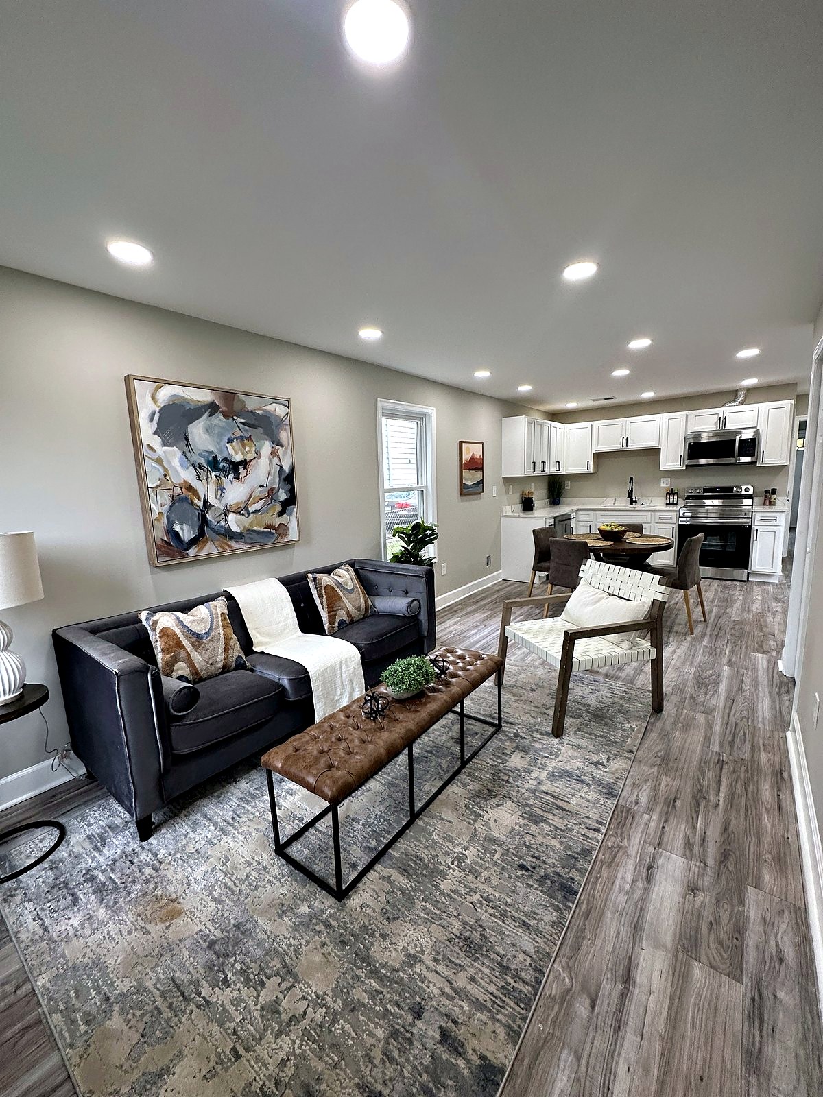 Renovated living room open to a white kitchen