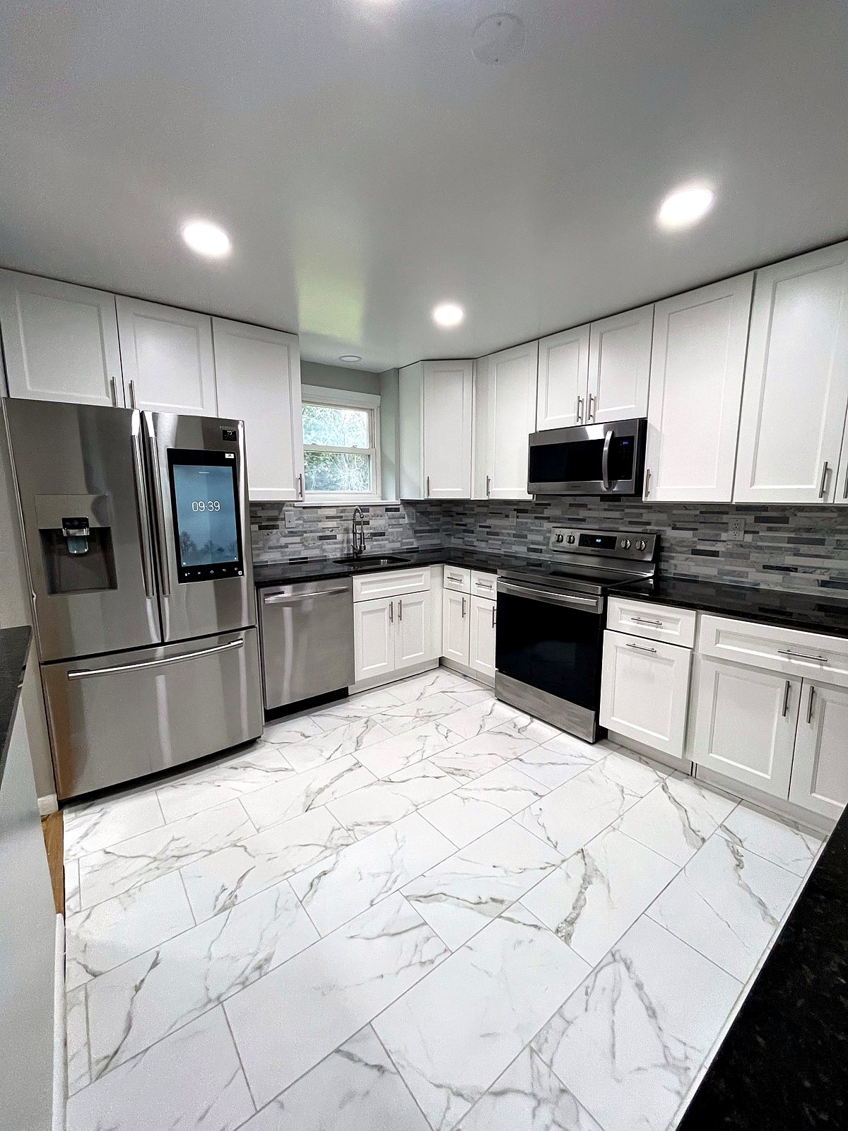 White shaker kitchen with marble-look tile floor